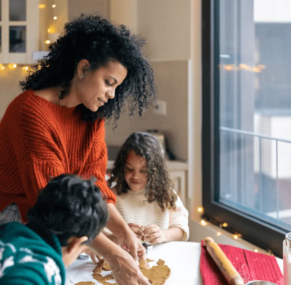 Family bakes cookies by a window.