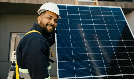 A woman laying on a roof, basking in the sun next to her solar panels